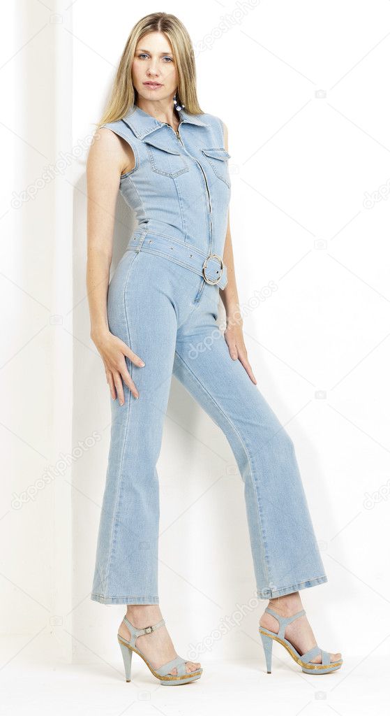 standing woman wearing denim overalls and summer shoes
