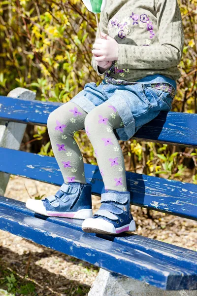 Close up of little girl sitting on bench — Stock Photo, Image