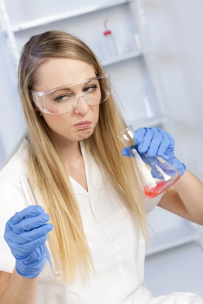 Mujer joven haciendo experimento en laboratorio —  Fotos de Stock