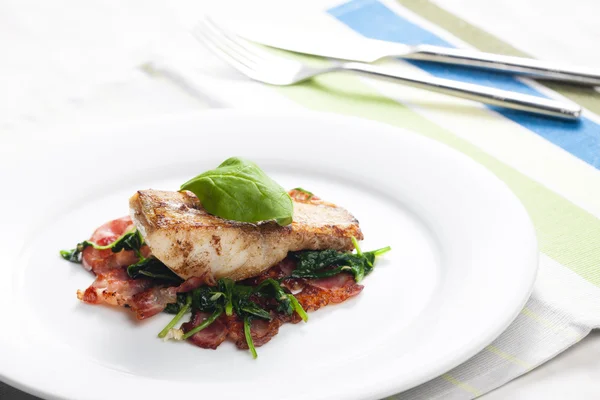 Tilapia filet met warme spinazie en spek salade — Stockfoto