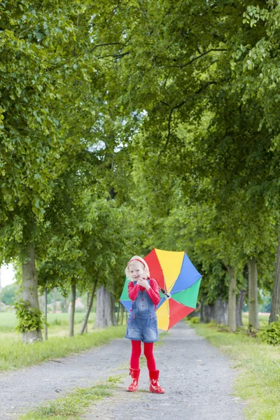 Little girl with umbrella in alley — Stock Photo, Image