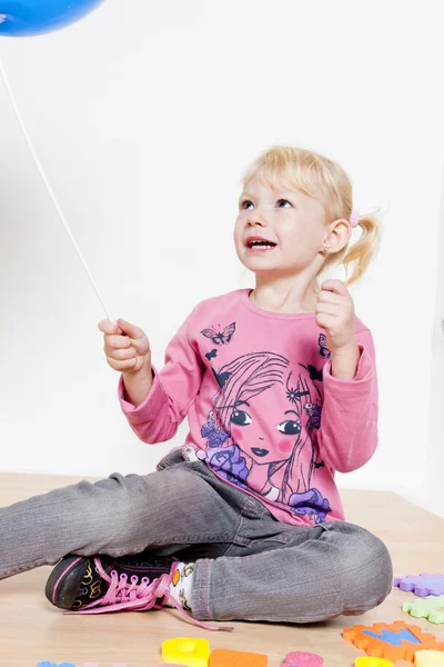 Jugando niña sosteniendo globo — Foto de Stock