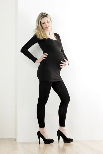 Pregnant woman wearing black clothes and pumps — Stock Photo, Image