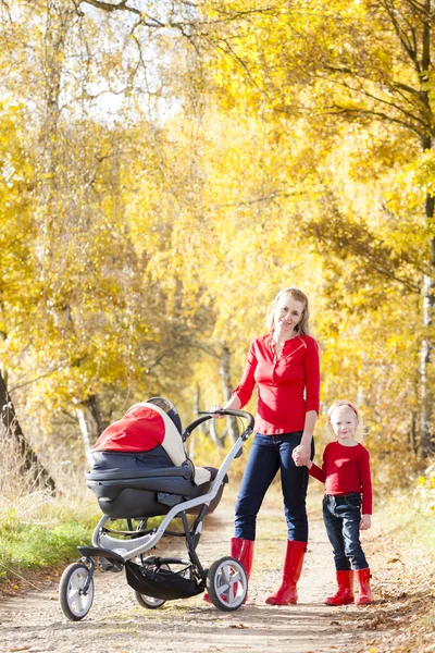 Matki i córki z wózka na spacer jesienny aleja — Zdjęcie stockowe