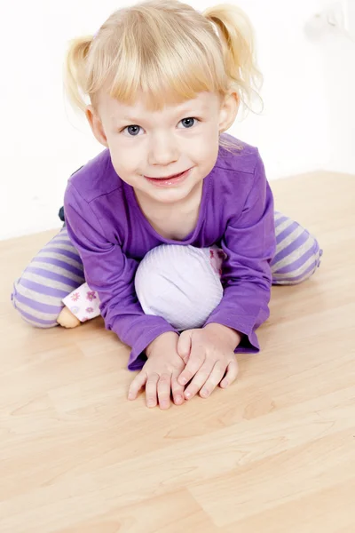 Porträtt av lilla flicka som leker med en docka — Stockfoto