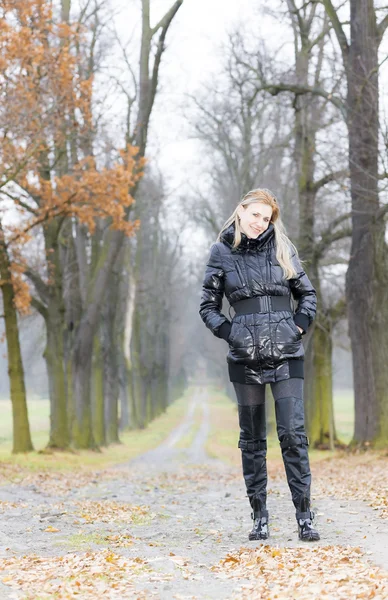 Mulher vestindo roupas pretas e botas em beco outonal — Fotografia de Stock