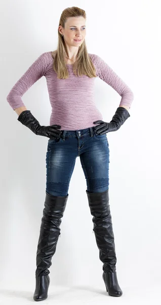 Mujer de pie con jeans y botas negras — Foto de Stock