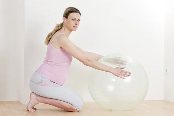Беременная женщина делает упражнения с мячом — стоковое фото