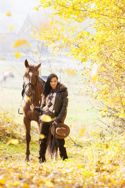 Ecuestre con su caballo en naturaleza otoñal — Foto de Stock