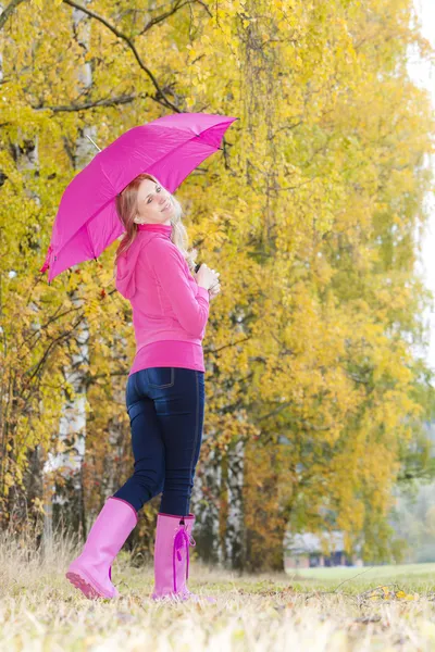 Kobieta ubrana gumowe buty z parasolem w jesienny natura — Zdjęcie stockowe