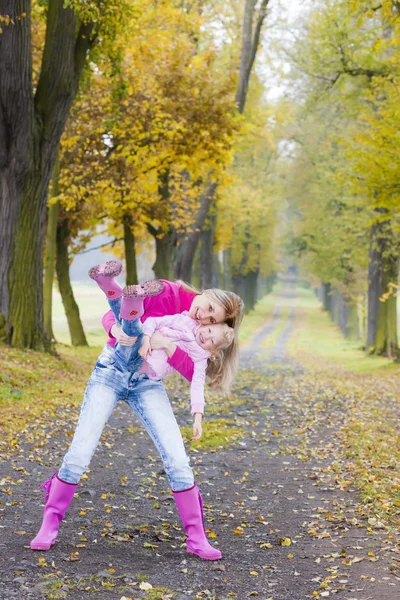 Moeder met haar dochter in herfst steegje — Stockfoto