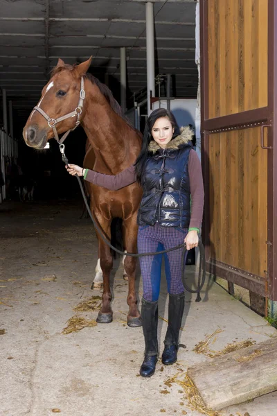 Equestrian with her horse in stable — Stock Photo, Image