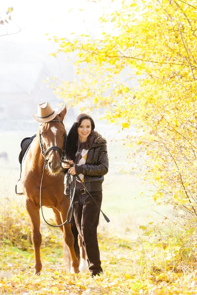Ecuestre con su caballo en naturaleza otoñal — Foto de Stock