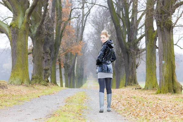 Frau trägt Gummistiefel in herbstlicher Gasse — Stockfoto