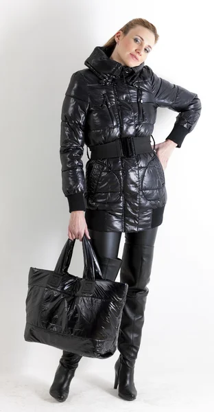 Mulher de pé vestindo roupas pretas segurando uma bolsa — Fotografia de Stock