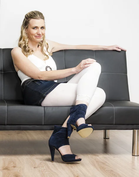 Woman wearing summer shoes sitting on sofa — Stock Photo, Image