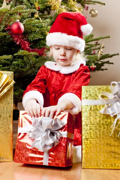 Klein meisje als santa claus met Kerst presenteert — Stockfoto