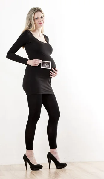 Mujer embarazada con una ecografía de su bebé — Foto de Stock
