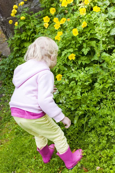 Маленькая девочка в резиновых сапогах в саду — стоковое фото