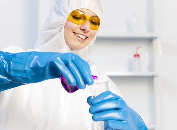 Giovane donna con cappotto protettivo in laboratorio — Foto Stock