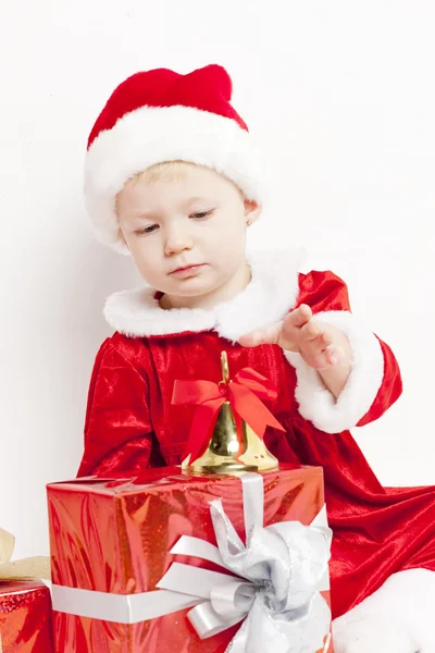 Klein meisje als santa claus met een bel en Kerst presenteert — Stockfoto