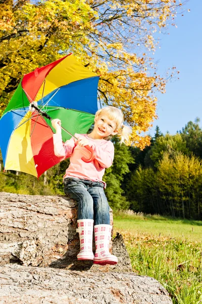 Liten flicka med paraply i höstliga naturen — Stockfoto