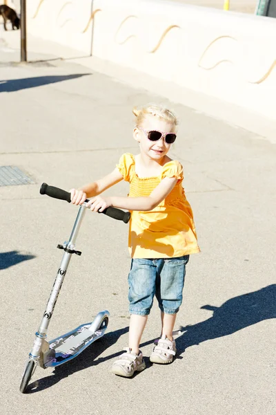 Kleines Mädchen mit einem Motorroller — Stockfoto