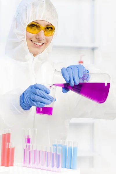 Młoda kobieta nosi płaszcz ochronny w laboratorium — Zdjęcie stockowe