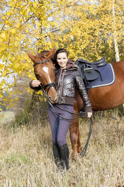 Equestrian with her horse on autumnal meadow — Stock Photo, Image