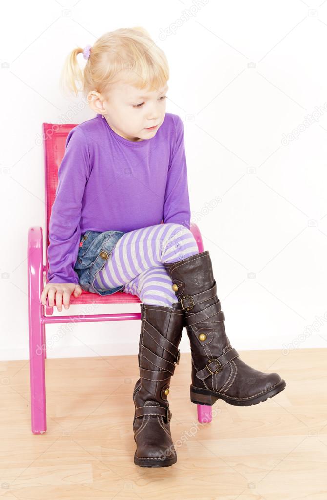 Lille pige støvler sidder på stolen — Stock-foto © phb.cz #27364401