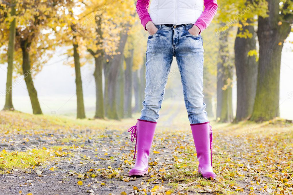 Detail of woman wearing rubber boots in autumnal alley — Stock Photo