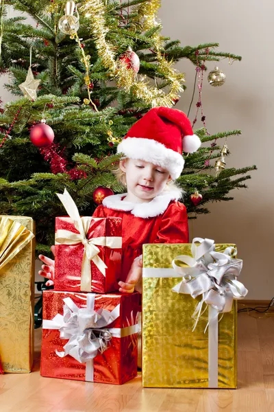 Dziewczynka jako santa claus z Boże Narodzenie prezenty — Zdjęcie stockowe