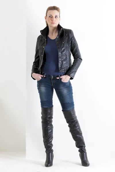 Standing woman wearing jeans and black boots — Stock Photo, Image