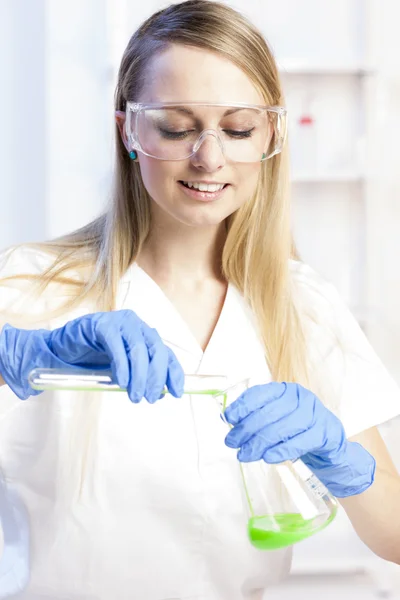 Mujer joven haciendo experimento en laboratorio —  Fotos de Stock