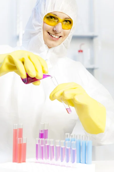 Mujer joven con abrigo protector en el laboratorio — Foto de Stock