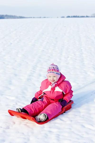 Little girl with bob in snow — Stock Photo, Image