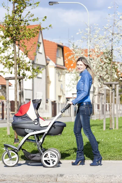 Kvinna med barnvagn på vår promenad — Stockfoto