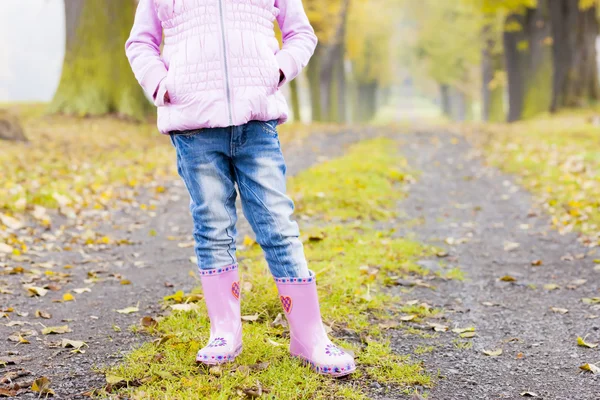 Detalj av liten flicka klädd i gummi stövlar i höstlig gränd — Stockfoto