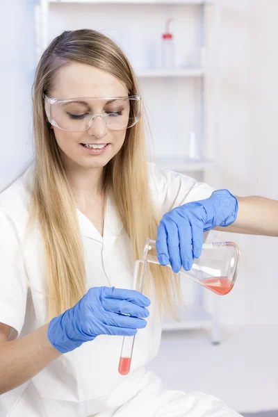 Mujer joven haciendo experimento en laboratorio — Foto de Stock