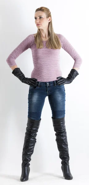 Femme debout portant un jean et des bottes noires — Photo