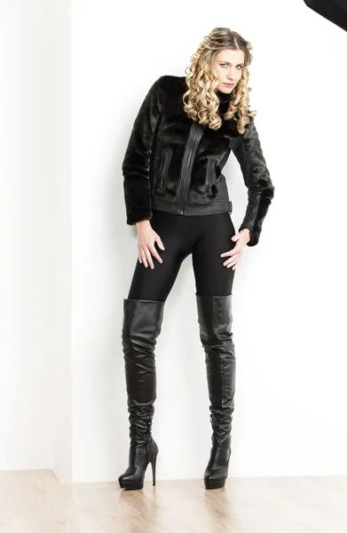 Mulher de pé vestindo roupas e botas pretas na moda — Fotografia de Stock