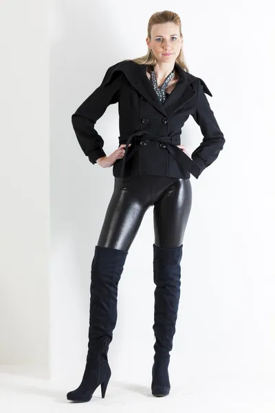 Mulher de pé vestindo roupas pretas e botas pretas — Fotografia de Stock