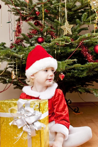 Holčička jako santa claus s vánoční dárek — Stock fotografie