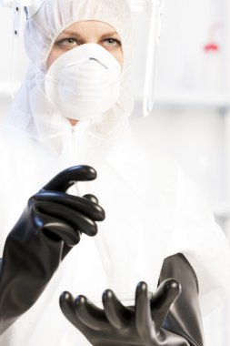 Laboratuvarda koruyucu elbise giyen genç bir kadın