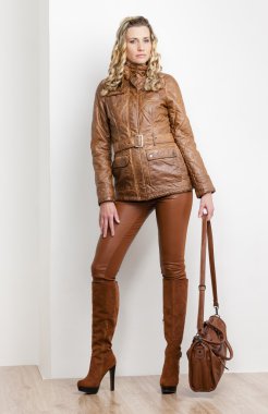 kahverengi giyimleri ve çizmeler giyen duran kadın