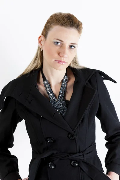 Portret kobiety stojącej na sobie czarny płaszcz — Zdjęcie stockowe