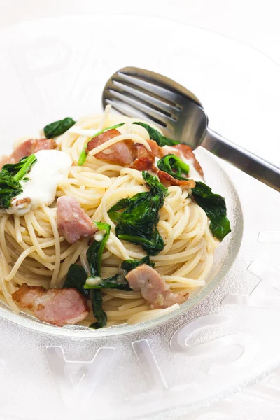 Спагетти со шпинатом, беконом и моцареллой — стоковое фото