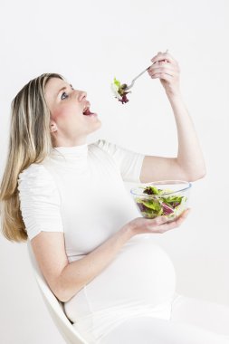 sebze salatası yerken hamile kadın portresi