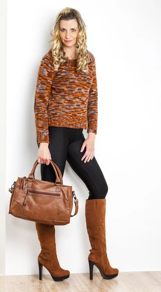 Femme debout portant des bottes marron à la mode avec un sac à main — Photo