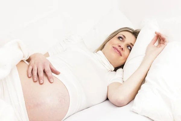 Gravid kvinna vilar i sängen — Stockfoto